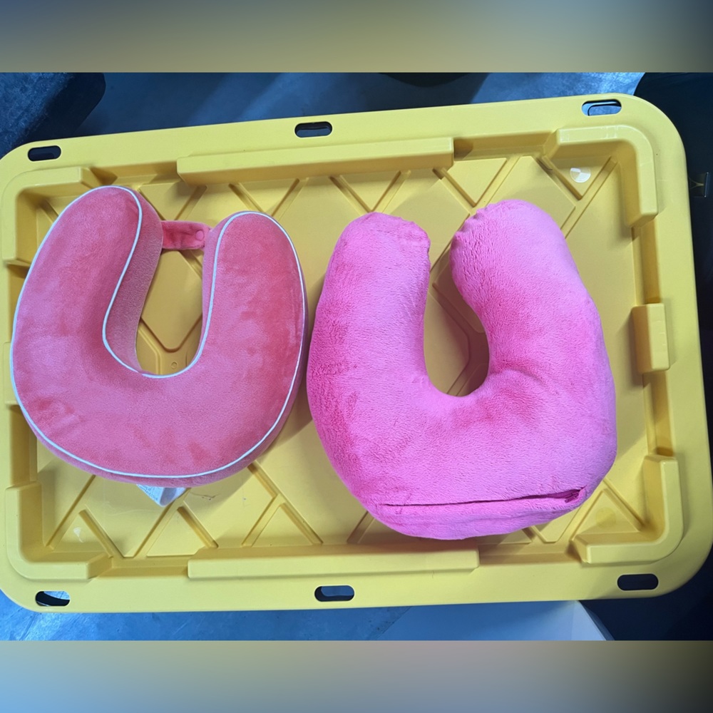 2 pink travel neck pillows. 1 fastens.